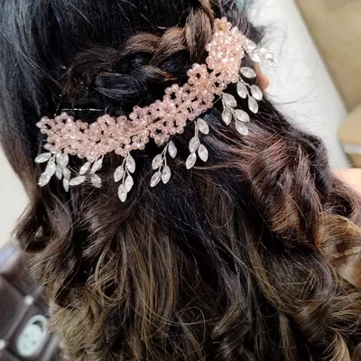 A beautiful example of accessorized hairstyling. This client's curls were enhanced with a delicate pink and crystal hairpiece, adding a touch of sparkle to her party look.