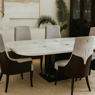 This is a full view of one of my signature dining collections in a beautifully styled room. The set includes a table with a polished white top and brass accents, paired with elegant dual-fabric chairs.