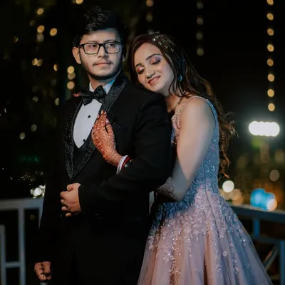 A romantic reception portrait under the stars. The bokeh from the fairy lights creates a magical, dreamy background, perfect for capturing the couple's quiet moment together after the wedding ceremony.