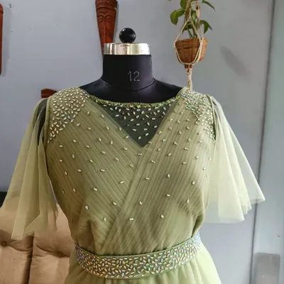 A closer look at the bodice of a student's final gown, featuring a sheer neckline and hand-placed embellishments. This level of detail is a hallmark of the skills we teach.