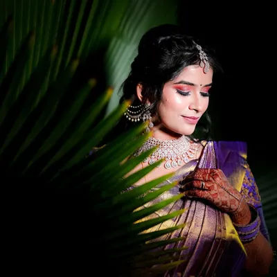 A creative portrait of the bride, her face partially hidden by a palm leaf. We use natural elements to create unique and artistic bridal shots.