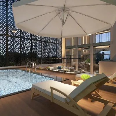 An evening view of the semi-enclosed rooftop pool at the Tata Executive Floor, featuring decorative screens for privacy and ambient lighting.