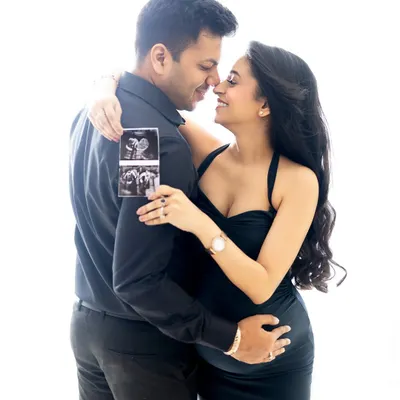 A classic couple's maternity portrait celebrating their upcoming arrival. Holding the sonogram picture adds a deeply personal and exciting touch to the announcement.