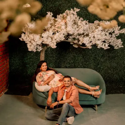 A dreamy studio setup for an expecting couple. The soft clouds and blossom tree create a serene, romantic atmosphere, perfect for capturing the magic of waiting for your baby together.