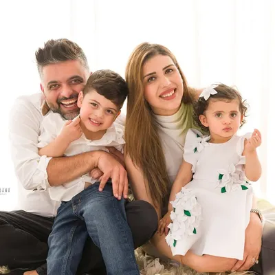 A warm and happy family portrait. The parents and their two children are all smiles in this classic, light-filled image.