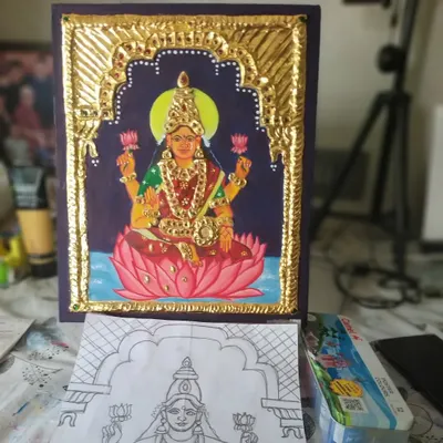 A complete Lakshmi Tanjore painting, shown alongside the initial sketch. This piece, featuring the Goddess of Prosperity on a lotus, is crafted with real gold foil and semi-precious stones, ready to bring blessings to your home.
