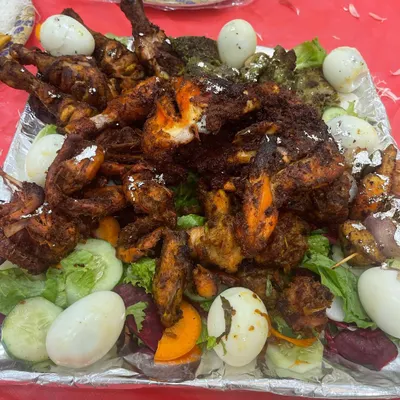 This platter shows the variety of starters I can provide, from whole chicken legs to smaller tikka pieces and kebabs, garnished with eggs and salad.