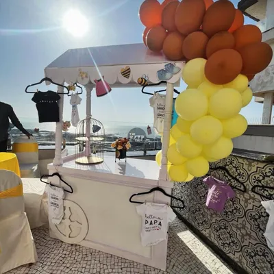 We styled this custom cart for a "Sweet as Can Bee" shower, complete with a balloon cascade and hangers for displaying adorable themed baby onesies. It's a perfect station for gifts, desserts, or just as a unique photo prop.
