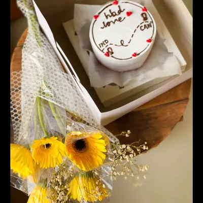 A simple yet beautiful gift combo. This set pairs a custom bento cake, designed with a long-distance love theme from India to Canada, with a lovely bouquet of fresh yellow gerbera daisies.