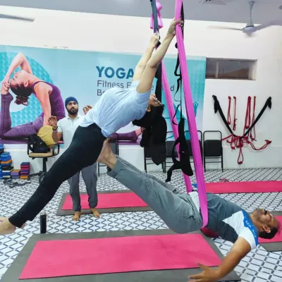 Here I am assisting a student in a partner aerial pose. The hammock provides support, allowing one student to fly while the other acts as a grounding base.