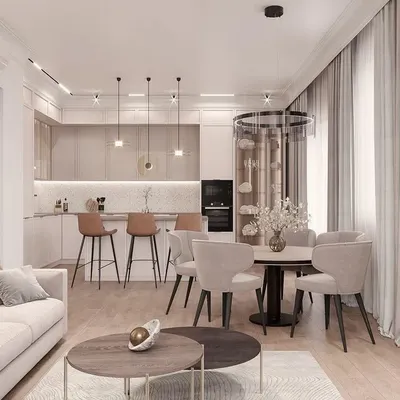 This view showcases the seamless integration of an L-shaped kitchen with the main living area. By using a consistent neutral palette and warm wood flooring throughout, the entire space feels unified and expansive. The design includes a breakfast bar for casual seating and layered lighting to define each zone.