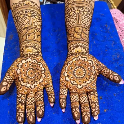 A perfect example of traditional Indian mehendi, featuring a central mandala design on the palm. This symmetrical style is timeless and elegant.