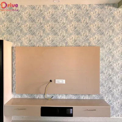 A well-chosen wallpaper can serve as the perfect backdrop. This modern botanical print installed behind a TV console adds visual interest without overwhelming the living room space.