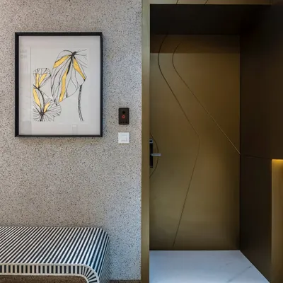 Embrace elegance at the entrance of this Mumbai duplex. A matte gold main door invites with a promise of opulence, while a striking black and white bench sets the stage for the refined luxury that unfolds inside.