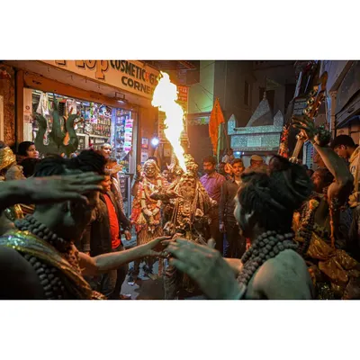 A performer breathes a plume of fire during a crowded night festival in the narrow streets of Varanasi. Capturing this moment required being in the heart of the procession to document its raw energy and spectacle.