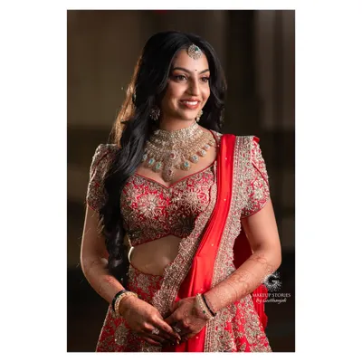 For her reception, Likitha switched to a glamorous red lehenga. We transitioned her makeup to a bolder look with soft smoky eyes, glowing skin, and beautiful wavy hair, perfect for an evening of celebration.