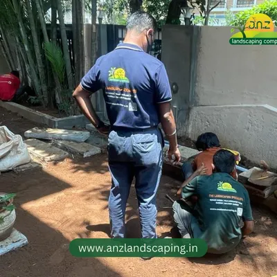 The first step in a great garden is proper preparation. Here, our team is leveling the ground and preparing the soil for lawn and pathway installation.