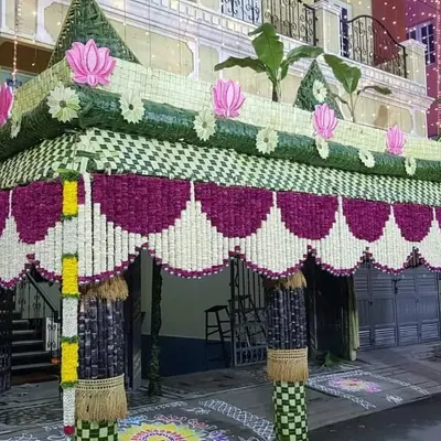 This grand chappra showcases intricate craftsmanship with woven leaf patterns, floral hangings, and pink lotus accents, perfect for a major celebration.