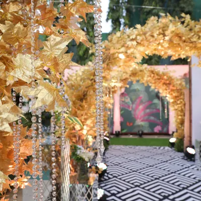 We created this enchanting golden forest entryway for a Sangeet night. The crystal strings and warm lights made guests feel like they were stepping into another world.
