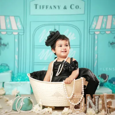 A glamorous first birthday shoot with our 'Tiffany & Co.' theme. The iconic blue backdrop and pearl accessories create a chic and stylish portrait.