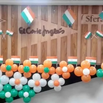 A close-up of a patriotic wall decoration for an office. I used tricolor balloons to create flower-shaped patterns, accented with small Indian flags, to create a simple yet festive look for a 15th August celebration.