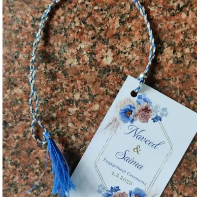 We design custom tags for all types of events. This elegant tag was created for an engagement ceremony, featuring a blue floral design and a matching tassel to attach to favors or gifts.
