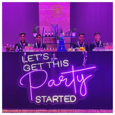 We set the mood for the night. This custom neon sign, "Let's Get This Party Started," makes it clear where the fun is at, with our professional team ready to serve.
