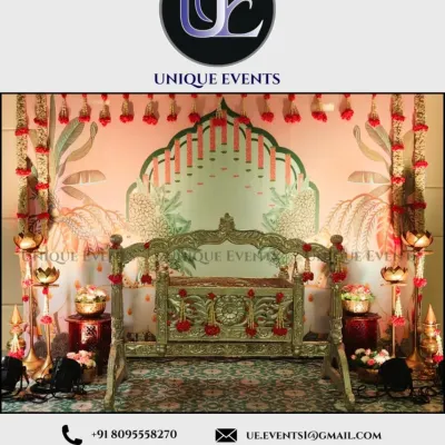 This traditional naming ceremony decor is rich with cultural details. The setup includes a hand-carved wooden cradle, lotus-shaped lamps, and a backdrop inspired by classic Indian art, creating a perfect setting for the sacred event.