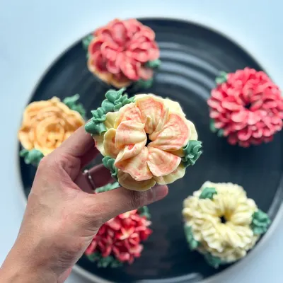 A closer look at my edible floral cupcakes. Each one is a mini work of art, with different flower designs like roses, dahlias, and succulents, all hand-piped with delicious buttercream in a variety of colors.