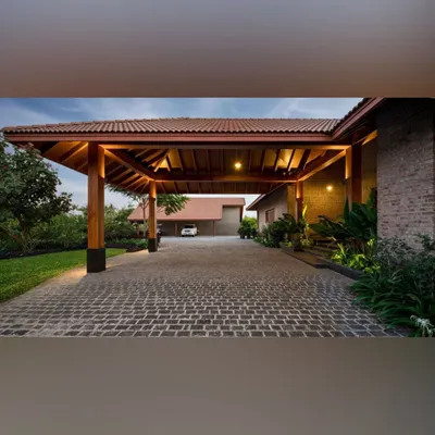 A cobblestone driveway leads to a timber-framed porte-cochère. The entrance is softened by lush planting along the edges, creating a grand yet welcoming sense of arrival for this beautiful home.