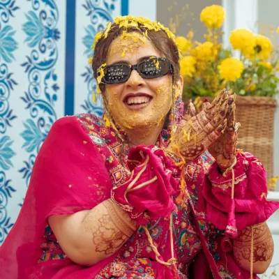 The pure joy of a haldi ceremony! This candid shot captures the bride's infectious laughter as she's covered in turmeric paste.