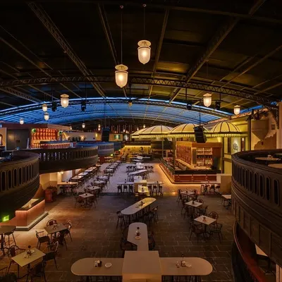 An overhead view of the entire Jollygunj space, showing the relationship between the different levels and seating zones. The design allows for both intimate corners and grand, open areas, unified by the warm, ambient lighting scheme.