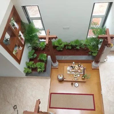 This top-down view shows how an indoor garden can transform a central courtyard or pooja area. The symmetrical design with lush palms brings life and serenity to the heart of the home.