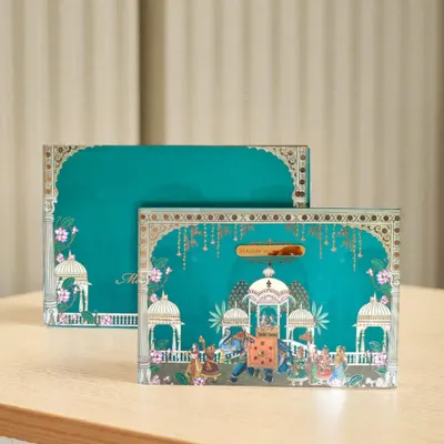 Another example of my Pichwai-themed collection, this invitation box features a royal procession with decorated elephants. The artwork is detailed with gold accents, making it a piece of art in itself.
