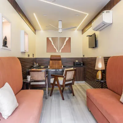 The main cabin view showcases the blend of modern and vintage styles. The coral sofas provide comfortable client seating without crowding the room, while the ceiling's profile lighting adds a contemporary touch.