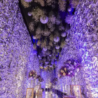 A breathtaking shot of the engagement party decor, featuring a ceiling filled with disco balls, flowers, and purple lighting. It's all about capturing the atmosphere.