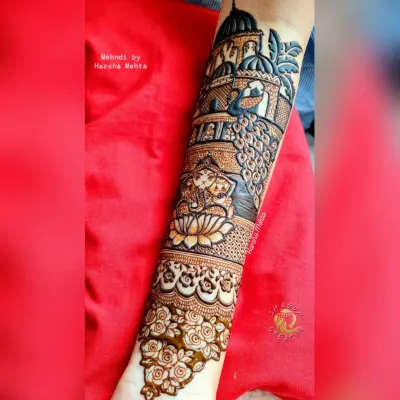 A divine creation on the arm, this design features Lord Ganesha seated on a lotus. He is surrounded by a peacock and elegant palace architecture, blending spirituality with royal motifs.