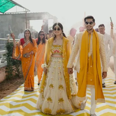 A perfect example of our custom couple outfits. The bride's yellow and ivory lehenga is perfectly coordinated with the groom's sherwani and yellow stole for their haldi ceremony.