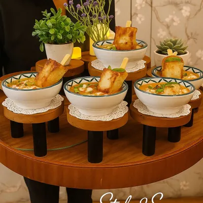 This is what we call 'Style to Serve'. Our staff presents dishes like this Khowsuey with fried tofu on unique, elevated trays, making it easy for guests to enjoy a delicious bite without leaving their conversation.
