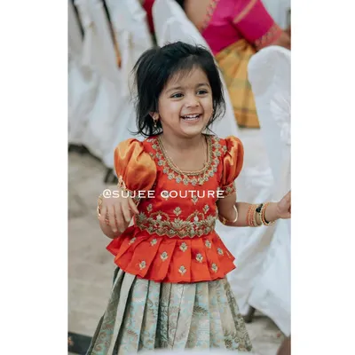 The beautiful Kanvi is wearing a custom-designed peplum blouse with traditional puff sleeves and intricate zardozi embroidery. I paired it with a light, pleated lehenga skirt, creating a complete ethnic wear set that is both stylish and comfortable enough for a child to enjoy any celebration.