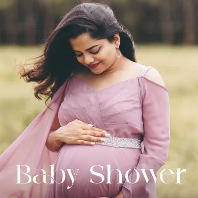 A moment of quiet reflection for the mom-to-be. This portrait in a beautiful mauve gown highlights the peaceful side of pregnancy amidst a soft, natural setting.