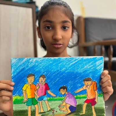 A student displays her memory drawing of children playing marbles. This is a key subject for grade exams, and we practice capturing movement and interaction between figures.