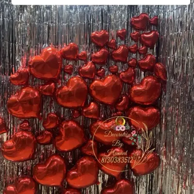 This is a detailed look at the wall of red heart foil balloons. The way they are clustered together creates a three-dimensional effect that is very eye-catching and perfect for a romantic surprise.