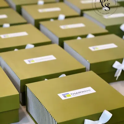For my corporate clients like Tharwani Realty, I design gift boxes that are both professional and personal. These custom-branded olive green and striped boxes were created for a large-scale event, reflecting the brand's identity with a clean, sophisticated aesthetic.