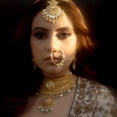 A powerful and artistic close-up of the bride. The dramatic lighting and her confident gaze create a portrait that is both beautiful and full of personality.