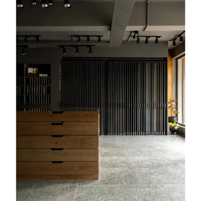 The interior of the boutique veneer showroom we designed in Bangalore. The space uses an earthy, moody palette with industrial elements like exposed track lighting and concrete floors to create a sophisticated backdrop for the wood products.