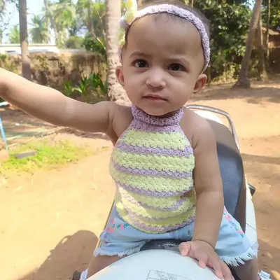 My daughter enjoying a sunny day in the Lavender Halter Top. This style is perfect for the beach or a playdate, made with soft, striped yarn that is gentle on the skin.