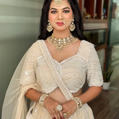 A stunning reception look in a white lehenga. The makeup is soft yet glamorous, with a focus on glowing skin and defined eyes.