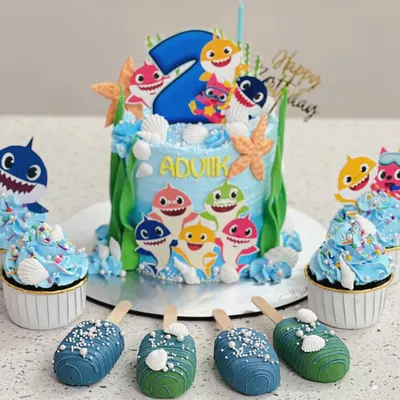 Doo doo doo! A fun Baby Shark themed set for a second birthday. I made a custom cake, matching cupcakes, and even themed cakesicles to create a complete dessert table.