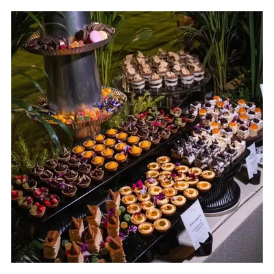 A dessert lover's dream. This lavish dessert spread features a multi-tiered display of chocolate tarts, fruit tartlets, mini cheesecakes, mousses, and traditional Indian sweets.